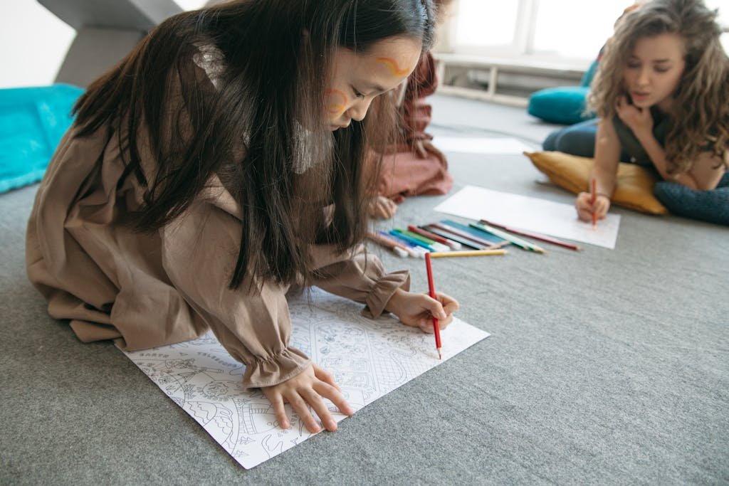Child drawing with colored pencils indoors, focusing on creativity and art.
