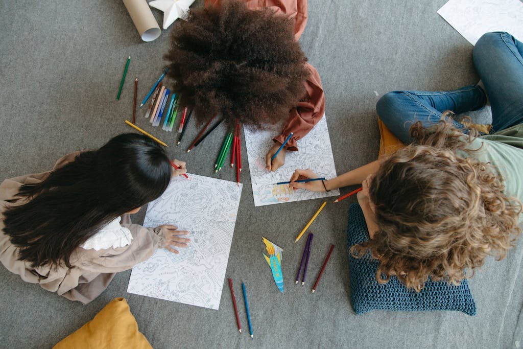 Overhead view of children coloring together, showcasing creativity and leisure.